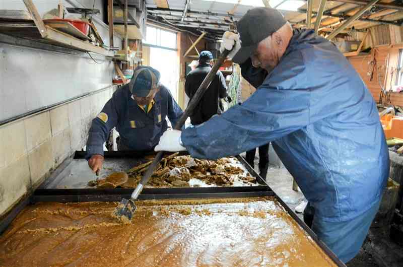 サトウキビの汁を手作業で煮詰めて冷ましてできた黒砂糖＝11日、天草市