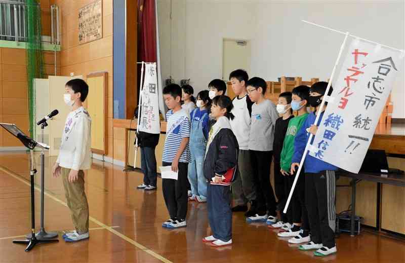 選挙の立候補者になりきって演説をする合志南小の児童ら＝15日、合志市