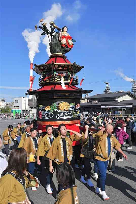 JR八代駅前を進む笠鉾の菊慈童。復元新調した水引幕を初披露した＝11月23日、八代市（上杉勇太）