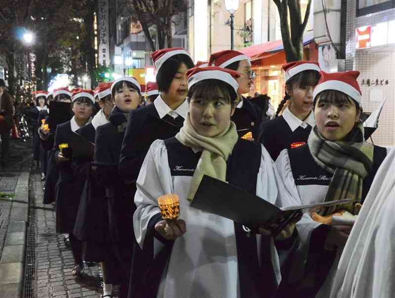 聖歌を歌いながら並木坂を歩く熊本信愛女学院の生徒たち＝24日、熊本市中央区