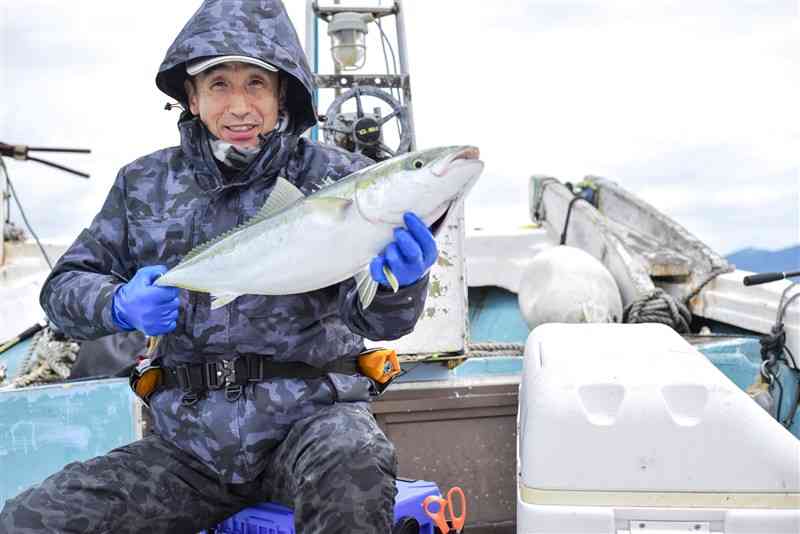 山口研二さんは7キロのブリを釣り揚げた＝天草市の牛深沖