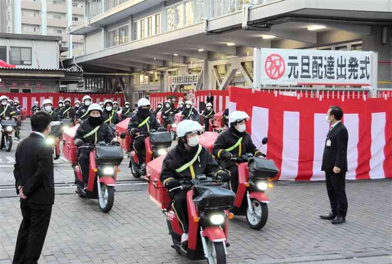 年賀状を積んだバイクで熊本中央郵便局を出発する配達員ら＝1日午前7時半ごろ、熊本市中央区