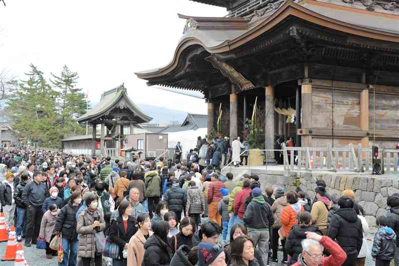 初詣客でにぎわう阿蘇神社。楼門前の参道には長い列ができた＝1日、阿蘇市