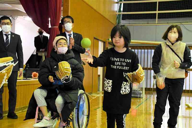 大谷翔平選手から贈られたグラブでキャッチボールをする熊本支援学校の児童＝9日、熊本市中央区