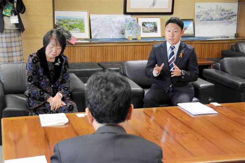 大西一史熊本市長（手前）に「子ども大学」への協力を要望した宮津航一さん（右）と田尻由貴子さん＝9日、市役所