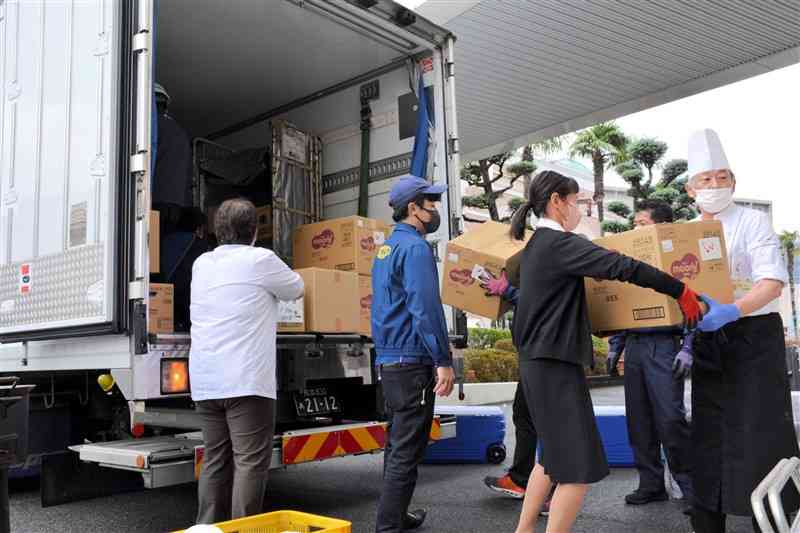 能登半島地震の被災地支援で使用する食材などをトラックに積み込む慈恵病院の職員ら＝10日、熊本市西区