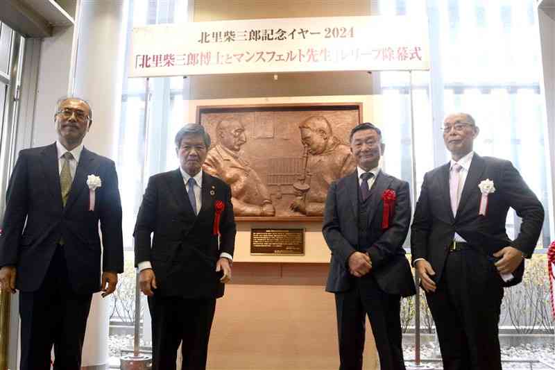 北里柴三郎と恩師のマンスフェルトが描かれたレリーフの除幕式＝11日、熊本市中央区