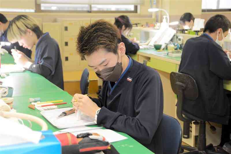 黙々と歯型を作る熊本歯科技術専門学校の学生。同校ではここ数年、入学者数が定員に届いていない＝2023年12月、熊本市中央区