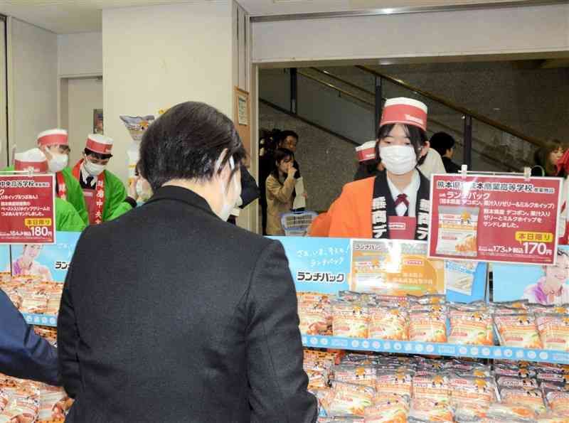 熊本県産のデコポンを使った「ランチパック」を販売する熊本商業高の生徒（右）＝15日、県庁