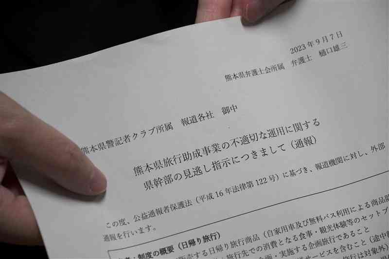 県の旅行割引事業を巡り、県上層部による見逃し指示があったと報道各社に外部通報した書面を持つ公益通報者＝熊本市中央区