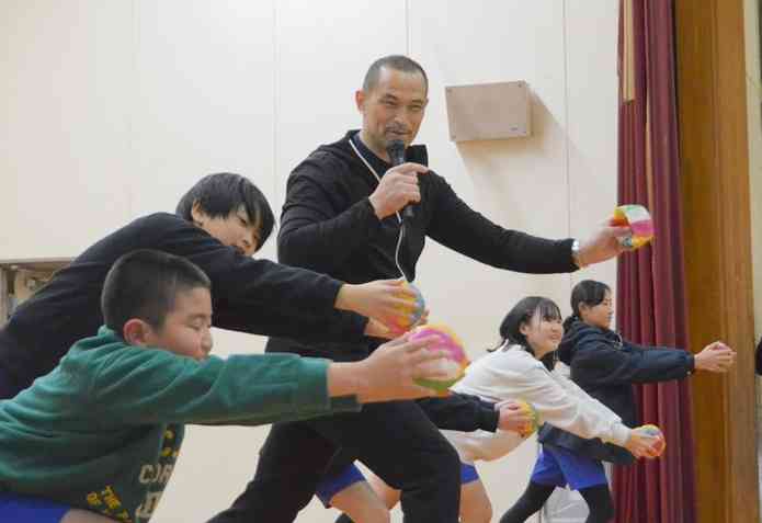 児童に紙風船を使ったトレーニングを指導する室伏広治さん（中央）＝18日、熊本市中央区