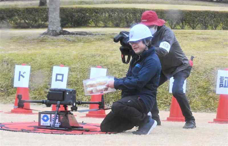 ゆのまえグリーンパレスに到着したドローン。ケーキを崩さずに運んだ＝18日、湯前町