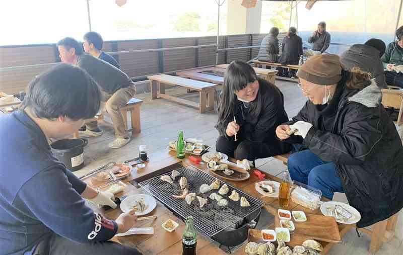 「つなぎオイスターバル」で焼きガキを楽しむ家族連れら＝20日、津奈木町