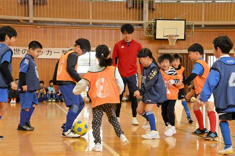 母校・代陽小の児童らと交流するデフサッカー日本代表の湯野琉世選手（中央）＝21日、八代市