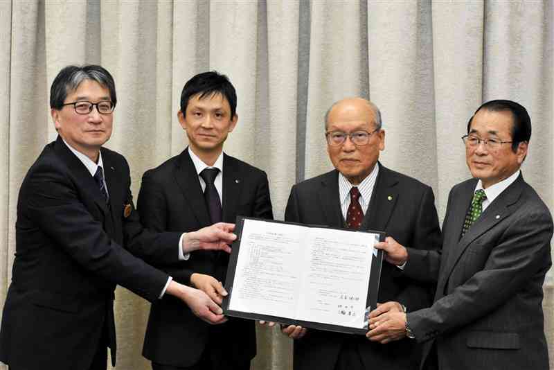 嘉島町と立地協定を結んだ尾家産業の尾家健太郎社長（左から2人目）ら＝23日、熊本市中央区