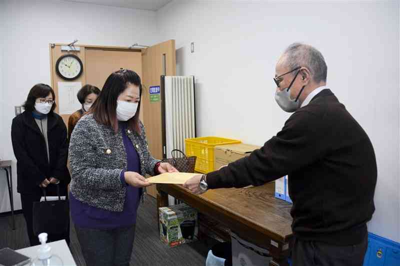 災害公営住宅建設の白紙撤回を求める意見書を人吉市の監査委員（右）に提出する「市民の会」のメンバー＝24日、人吉市