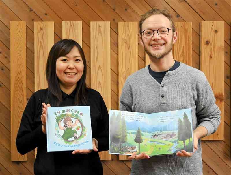 創作した絵本を手に「元気な森の大切さを伝えたい」と話すワル・マックスさん（右）と、小国町森林組合の渡邉久美子さん＝24日、小国町