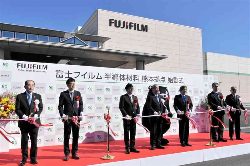 富士フイルムの菊陽工場が半導体材料の生産拠点として始動することを祝い、テープカットする関係者ら＝25日、菊陽町