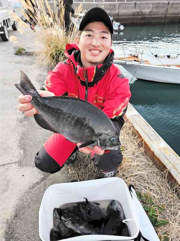 釣り揚げた良型の寒グロを手にする橋口拓哉さん＝天草市天草町高浜