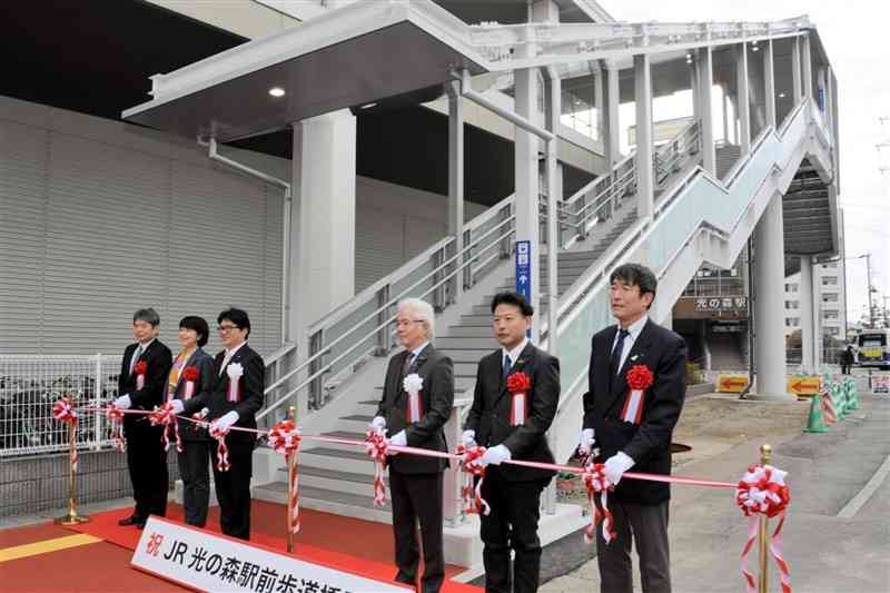 吉本孝寿町長（左から3人目）らがテープカットして開通したJR光の森駅前の歩道橋＝30日、菊陽町