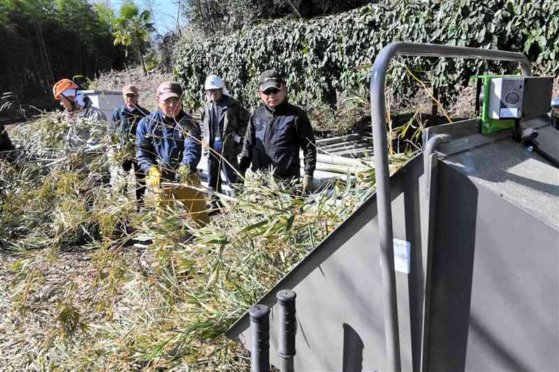 伐採した竹を粉砕機にかける東福寺周辺整備委員会のメンバー＝1月25日、菊池市