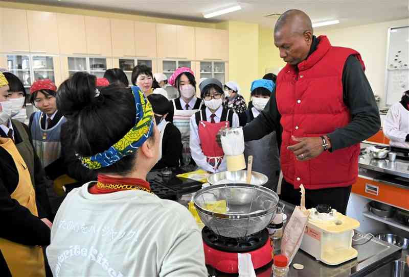 ケニアのデザートの作り方を教えるワシルワ・ナッサン・デビットさん（右）＝１月29日、菊池市