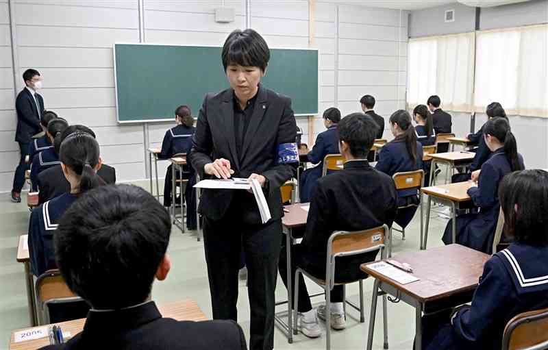 第一高普通科英語コースの前期（特色）選抜で、受験票の確認をする試験監督＝1日午前9時20分ごろ、熊本市中央区（石本智）