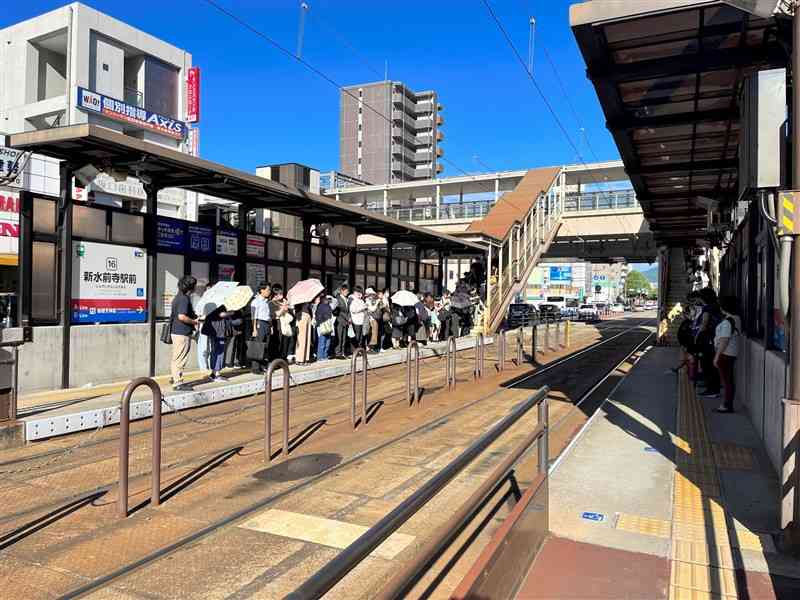 午前8時ごろの新水前寺駅前電停。市電を待つ利用者が電停内に収まらず、JR新水前寺駅につながる階段まで並んでいる＝2023年9月、熊本市中央区（市提供）