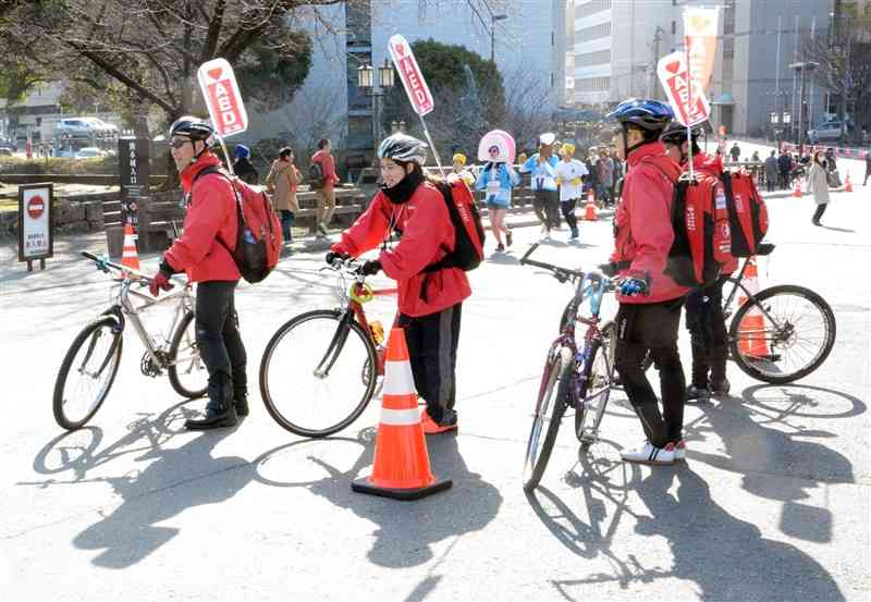 熊本城マラソンの「城下町4キロ」のコースを自転車で巡回するモバイルAED隊＝2016年、熊本市中央区