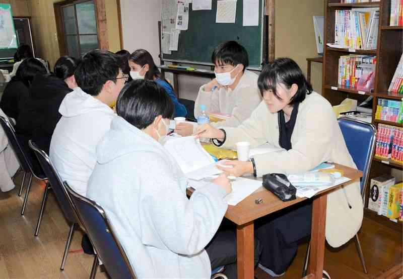 地域の学習教室「子ども支援塾ステップ」で、大学生に教えてもらいながら受験勉強に励む中学生ら＝1月中旬、熊本市中央区