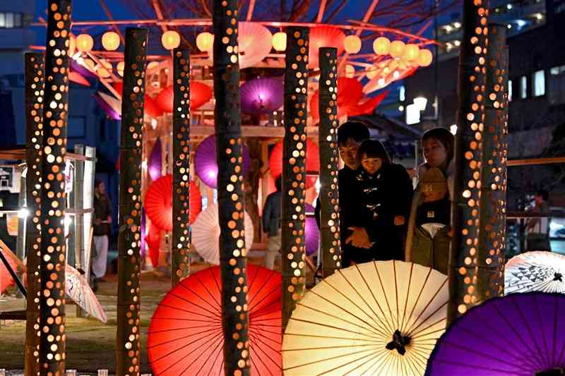 「百華百彩」が始まり、和傘や竹灯籠の明かりで彩られた湯の端公園＝2日夜、山鹿市（上杉勇太）