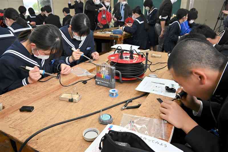 電子工作を通して半導体の役割を学ぶ生徒たち＝5日、菊池市