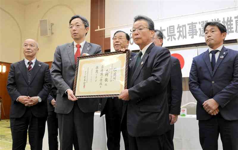 木村敬氏（前列左）に推薦状を手渡した県農業者政治連盟の宮本隆幸委員長（同右）＝6日、熊本市中央区