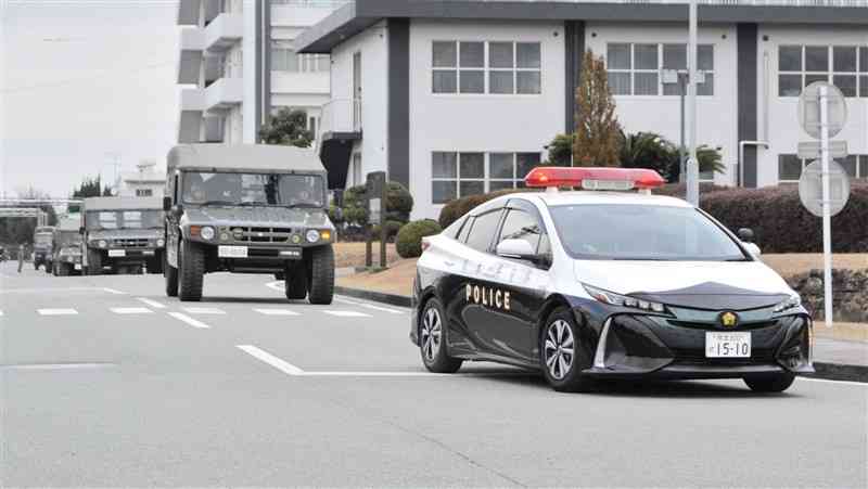 共同訓練で自衛隊車両を先導する熊本県警のパトカー＝7日午前、熊本市北区