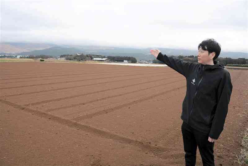 地元特産のカライモを栽培する農地に立つ中瀬靖幸さん。「このまま農業が続けられるのか」と将来への不安も口にする＝5日、大津町