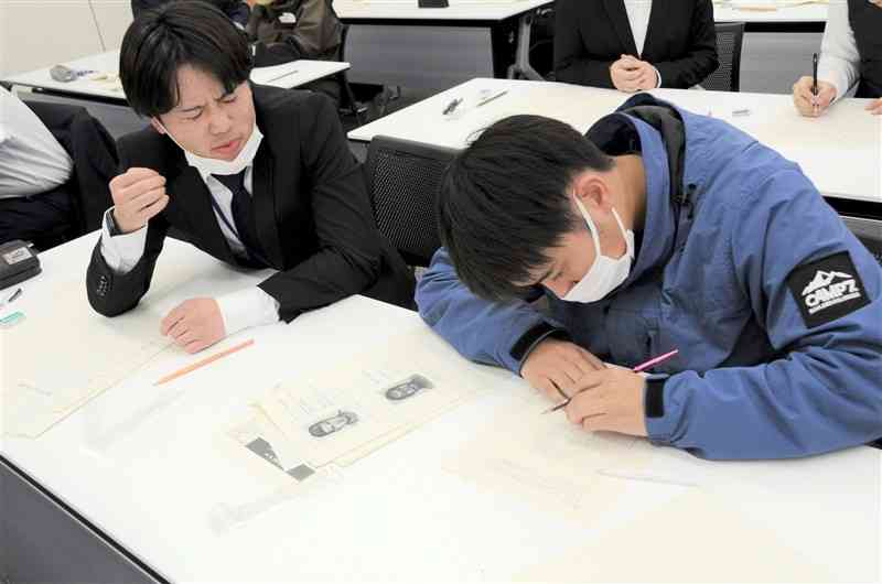 目撃者役（左）から引き出した情報を基に似顔絵を描く参加者＝7日、熊本市中央区
