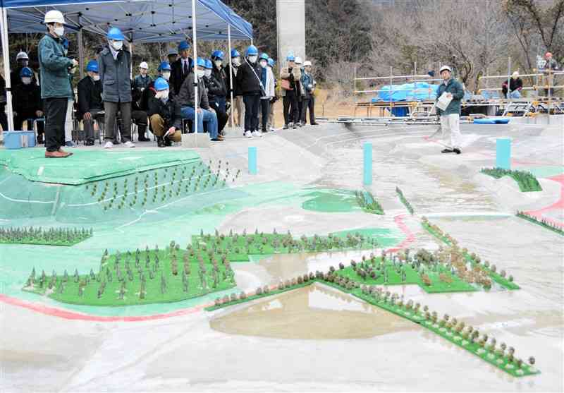 大型模型を使った実験で、五木村の一部が流水型ダムの貯水によって水没する様子を見学する村民ら＝3日、五木村