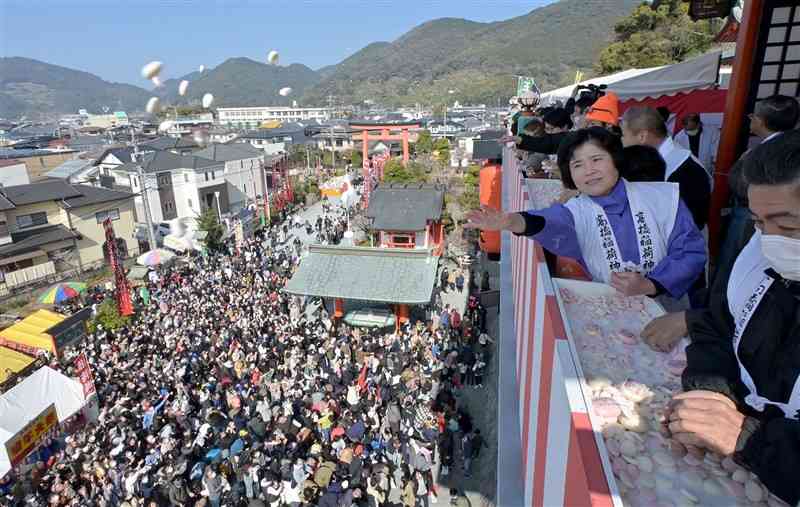 多くの参拝客に紅白餅をまく福男、福女たち＝12日午前、熊本市西区の高橋稲荷神社（谷川剛）