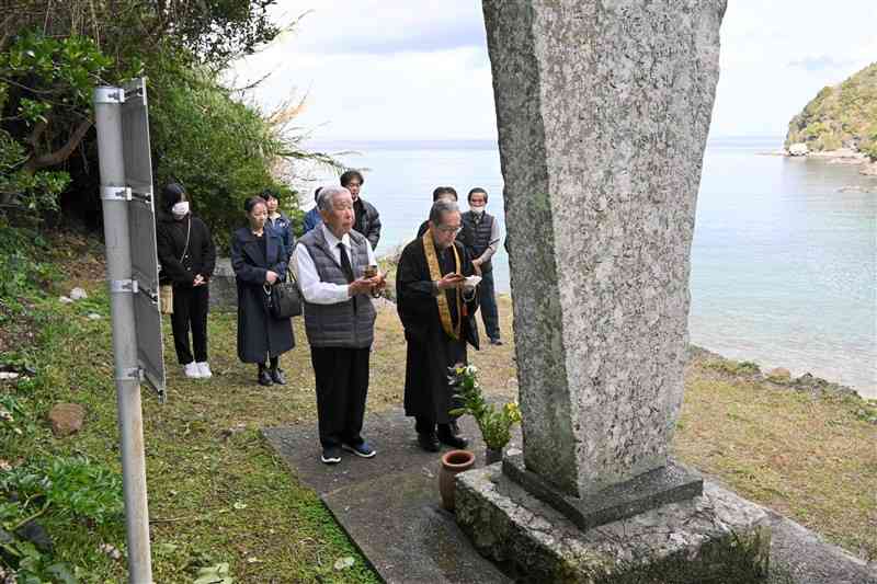 串地区の供養碑に花を手向け、犠牲者の冥福を祈る長洲町の関係者ら＝15日、上天草市