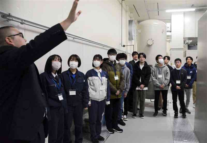 熊本県が企画した見学ツアーで、県防災センターの設備について職員から説明を受ける参加者たち＝17日、熊本市中央区