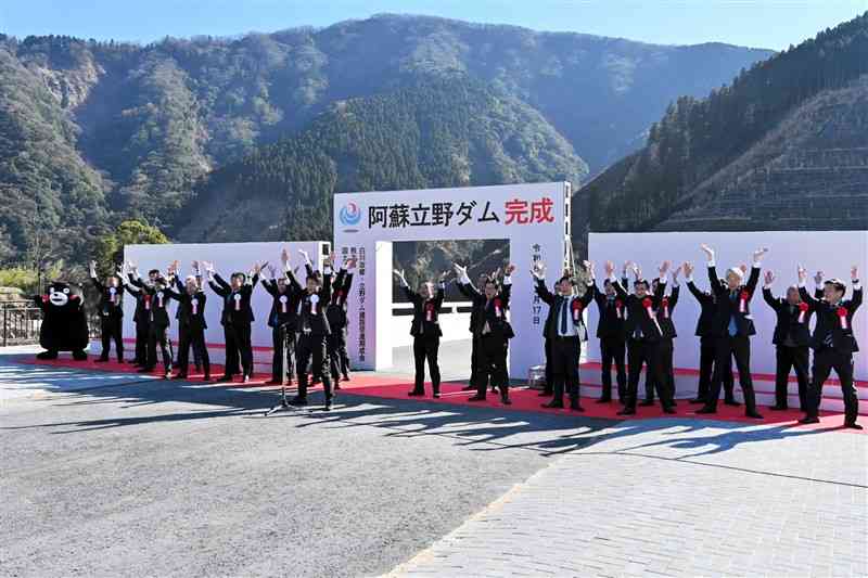 阿蘇立野ダムの完成式で万歳三唱して完成を祝う関係者ら＝17日、南阿蘇村
