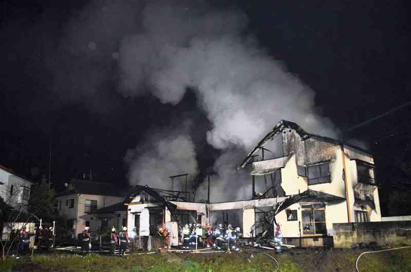 2階建ての民家1棟が全焼し、煙が上がる火災現場＝19日午後8時20分ごろ、熊本市北区