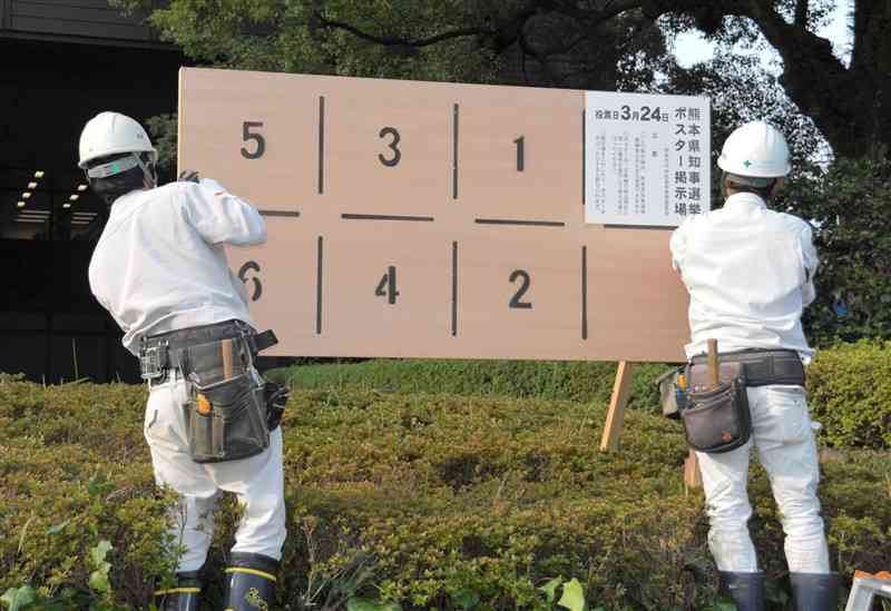 熊本市議会棟前に、知事選のポスター掲示場を設置する業者＝20日、熊本市中央区