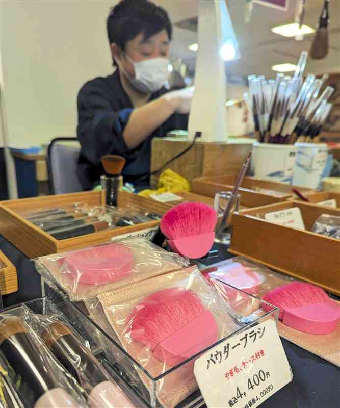 ピンク色をした熊野筆のパウダーブラシなどが並ぶ「くらしを彩る職人展」＝21日、熊本市中央区