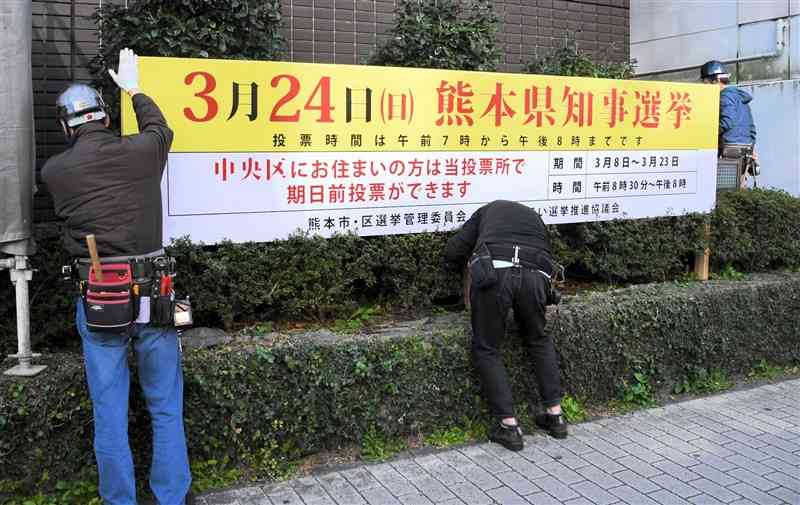 熊本県知事選の投票を呼びかける啓発看板を設置する業者＝26日、熊本市中央区