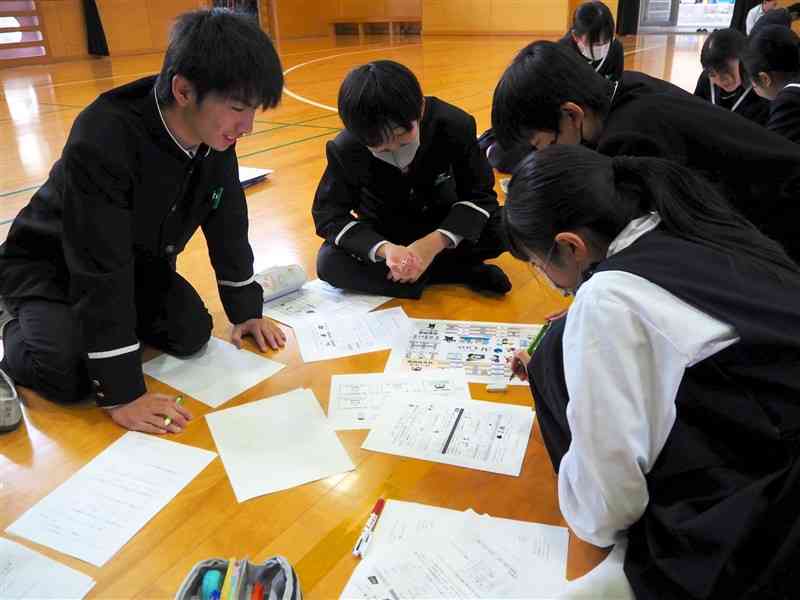 ボードゲームを楽しみながら、会社経営を学ぶ藤園中の生徒たち＝28日、熊本市中央区