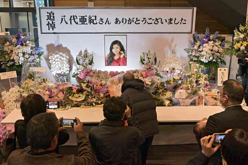 八代亜紀さんのお別れの会で、献花台を写真に収めて別れを惜しむ人々＝29日午後、八代市役所（上杉勇太）