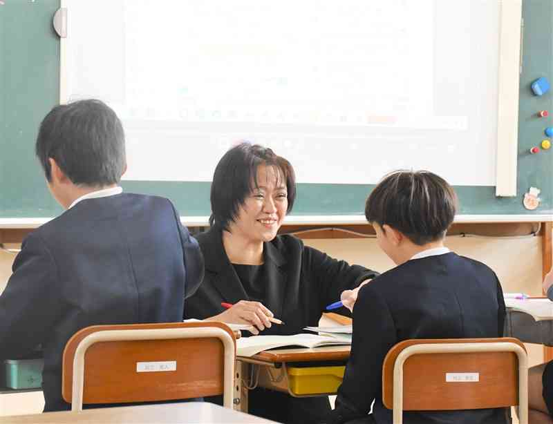 津奈木小の算数の授業で児童に笑顔で話しかける橋本めぐみさん＝2023年12月、津奈木町