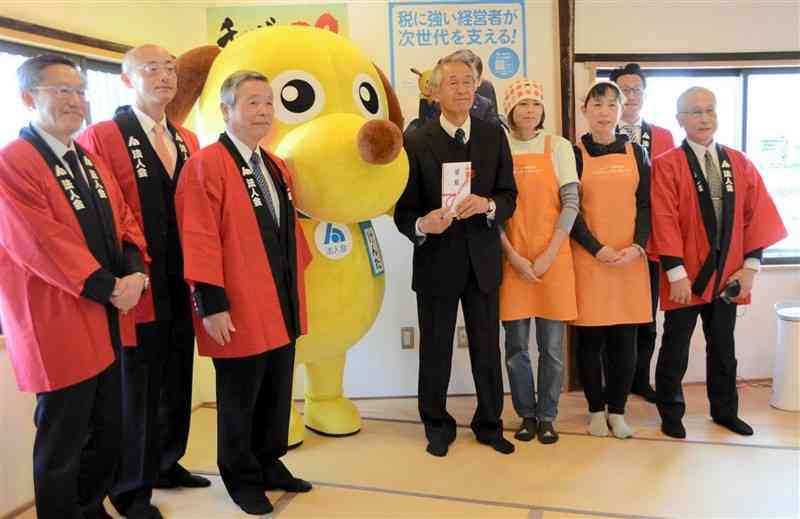 熊本県子ども食堂ネットワークへの寄付金贈呈式で記念撮影する関係者たち＝2日、熊本市南区