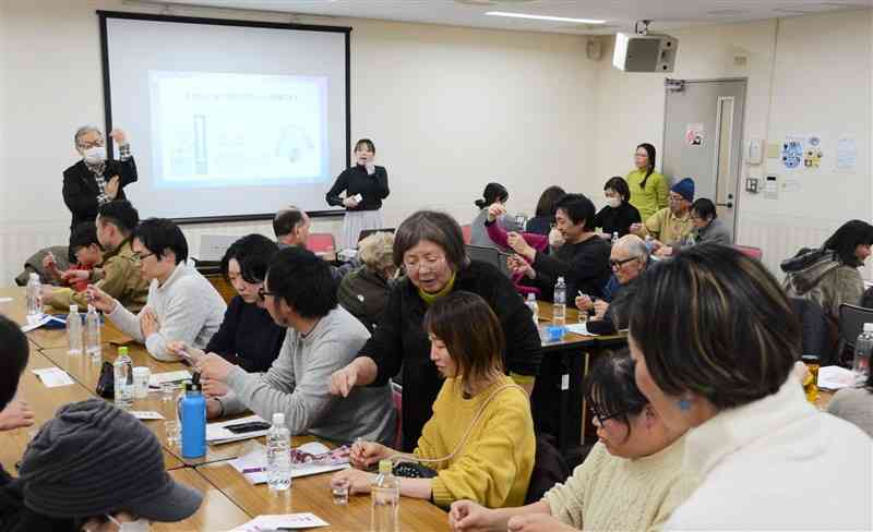 飲み水などの硝酸性窒素濃度を簡易検査で調べる、勉強会の参加者＝2日、熊本市中央区